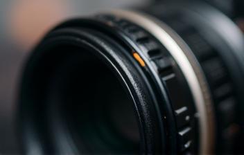 Close-up photo of a camera lens focusing on a subject